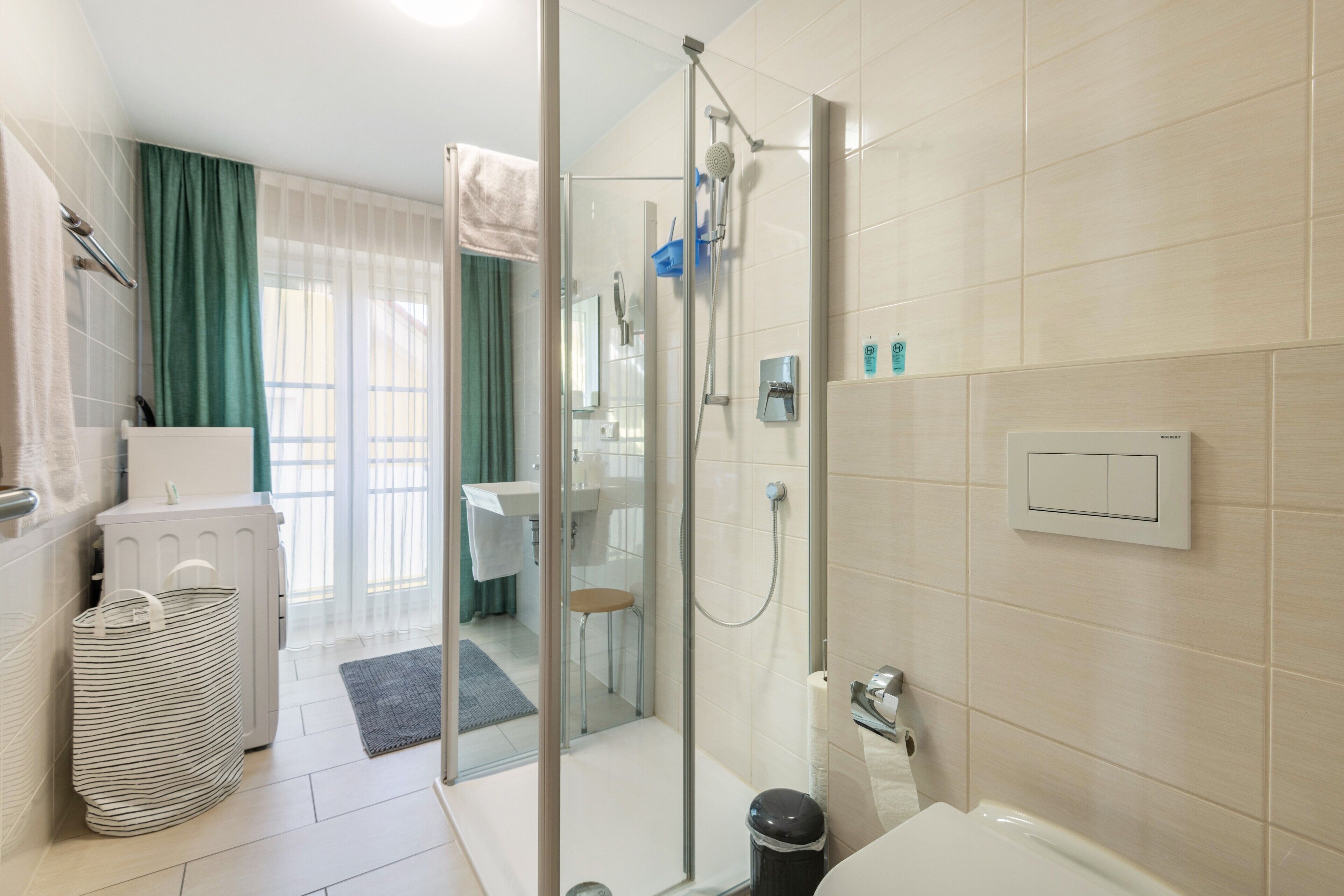 Ein modernes Badezimmer mit Duschkabine aus Glas, Toilette und Waschbecken.