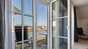 Quarto com porta de vidro deslizante que dá para área externa com mesa e cadeiras.