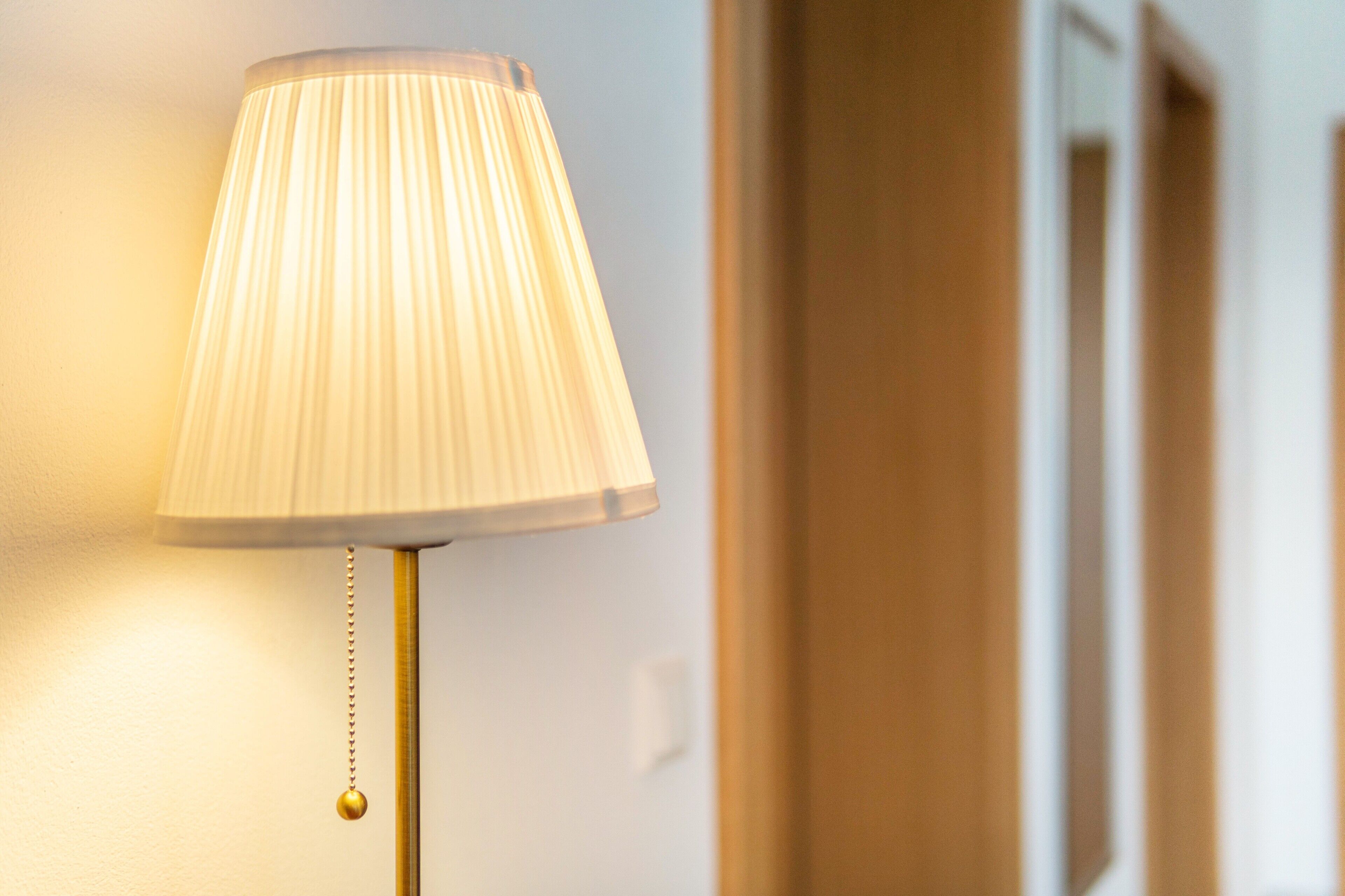 A lamp with a pleated shade and a gold-colored base.