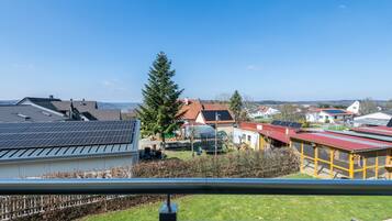 Un quartier résidentiel avec des maisons, des panneaux solaires et un grand arbre.