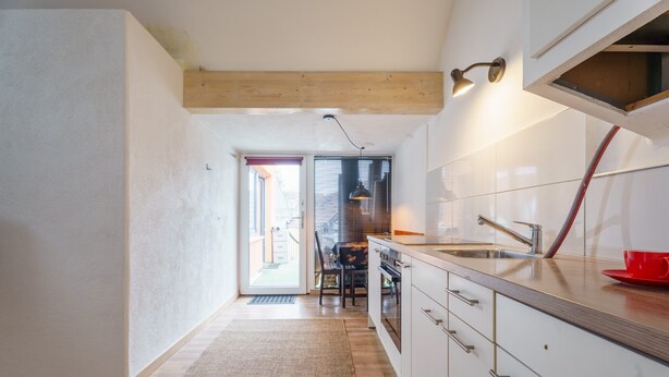 A kitchen with wooden beams, a sink, cabinets, and a red cup on the counter. - Apartment 'C' with Wi-Fi (Bühl)