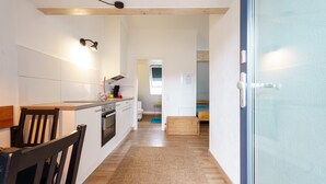 A modern kitchen with white cabinets, a wooden countertop, and a built-in oven. - Apartment 'C' with Wi-Fi (Bühl)