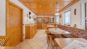 Un intérieur en bois comprenant un coin repas, des bancs et une cuisine.