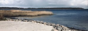 Un paisaje costero con una playa arenosa, un litoral rocoso y una masa de agua.