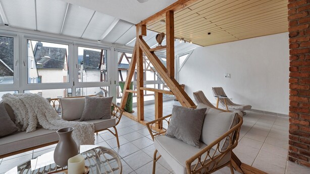 A modern interior with a high ceiling, large windows, and a wooden staircase. - Apartment 'Kaamter Ferkelsmarkt' with Wi-Fi (Zell an der Mosel)
