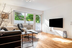 A modern living room with a sofa, coffee table, and a TV mounted on the wall.