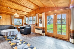 A wooden interior with a sofa, chairs, a table, and large windows. - 'Bergners' with Private Terrace and Wi-Fi (Unknown)