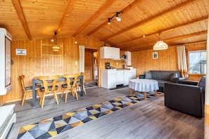 A wooden interior with a dining area, kitchen, and seating space.