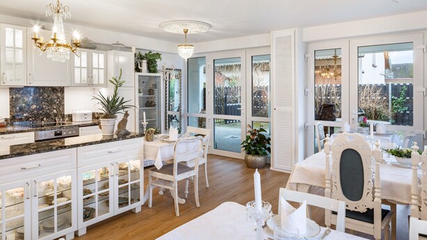 A kitchen with white cabinets, a granite countertop, and a chandelier. - Holiday Apartment 'Veilchen' with Shared Garden, Balcony and Wi-Fi (Vogtsburg im Kaiserstuhl)