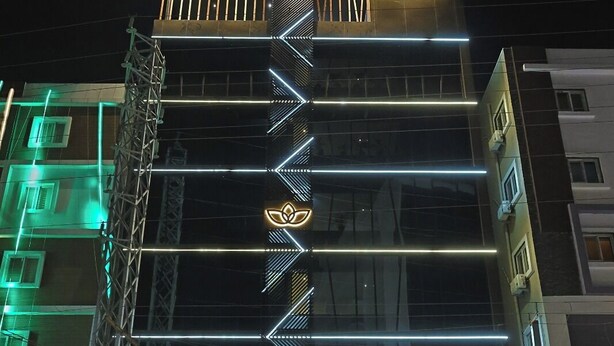 A hotel with a modern facade, a prominent logo, and a well-lit entrance. - Grand Continent Hotel Gachibowli, US Consulate (Hyderabad)