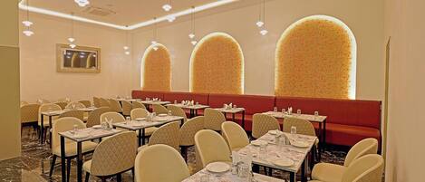 A restaurant with round tables, cushioned booths, and a marble floor.