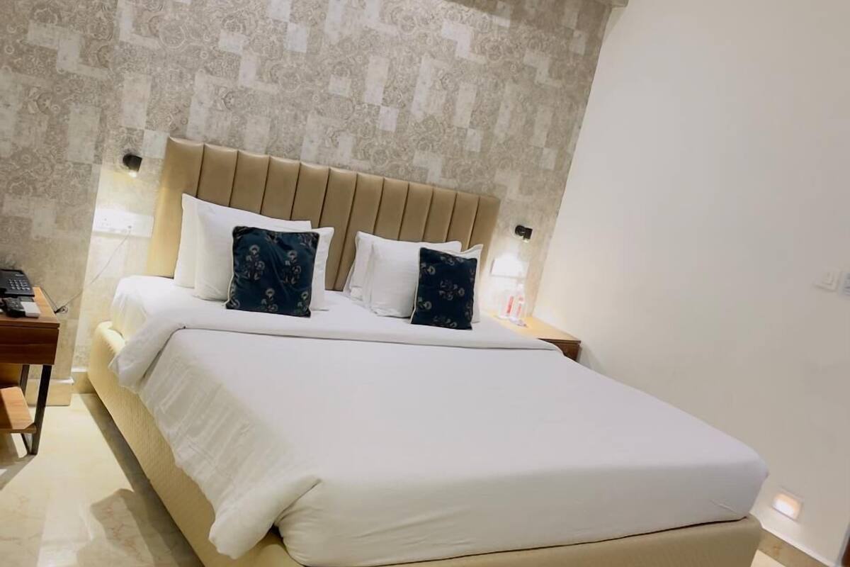 A bedroom with a large bed, a headboard, bedside tables, and a ceiling fan.