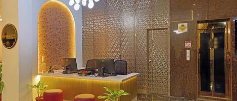 A reception area with a desk, computers, and a patterned wall.