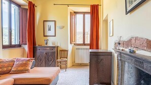 A bedroom with a bed, a dresser, a radiator, and a window with curtains. - Luxury Retreat in Montevettolini (Montevettolini)