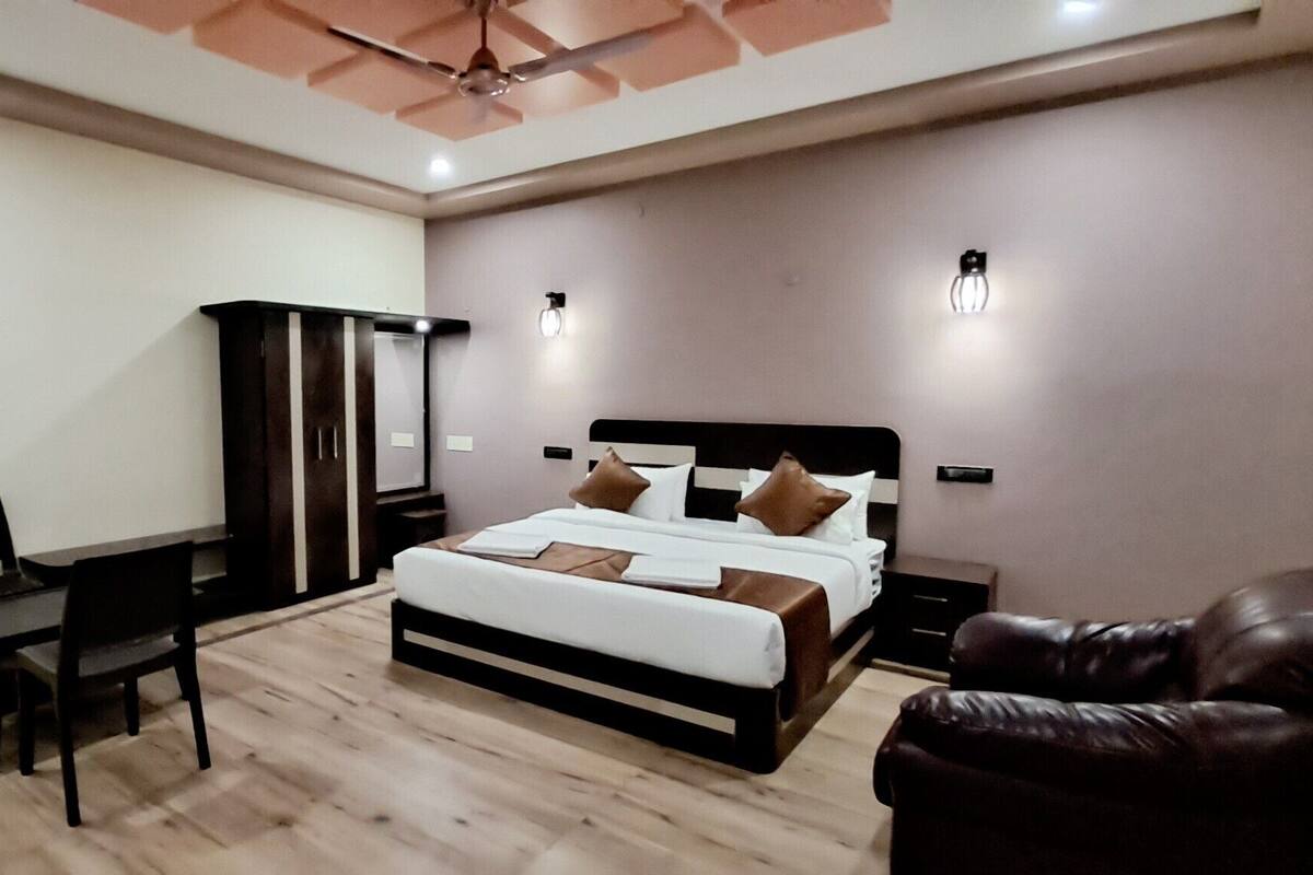 A modern bedroom with a bed, a wardrobe, a desk, and a chair.