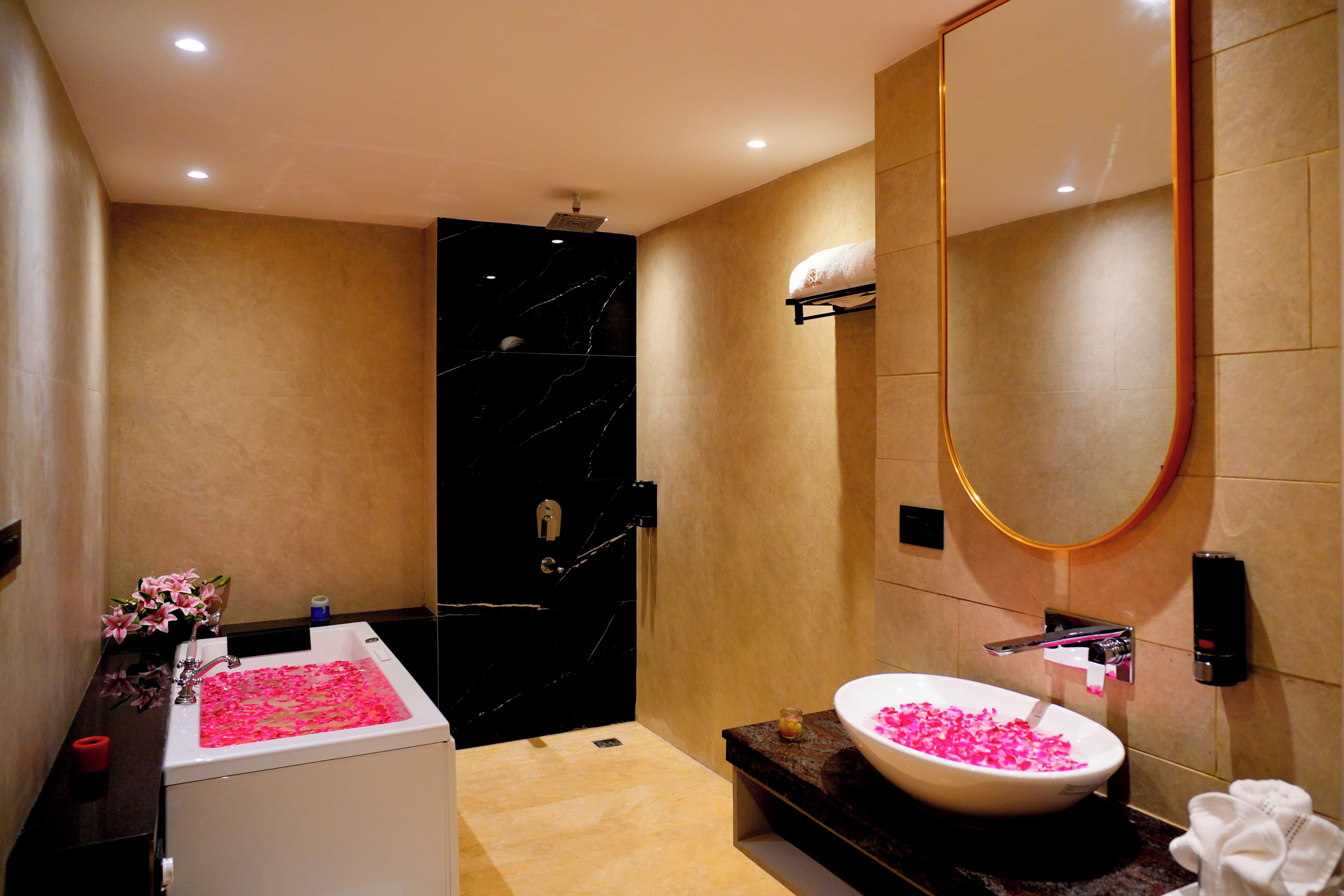 Un baño moderno con lavamanos de mármol, un espejo grande y una zona de ducha separada.