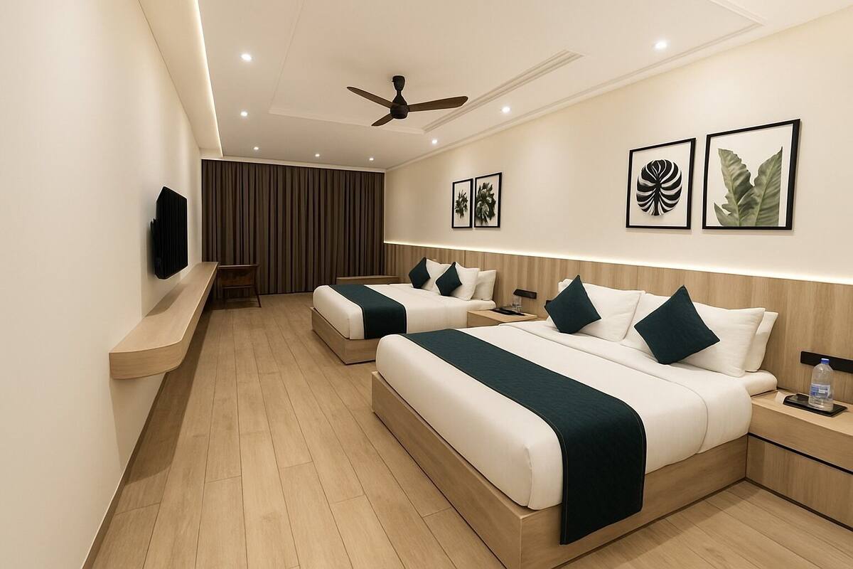 A modern hotel room with two beds, a flat-screen TV, a ceiling fan, and artwork on the walls.