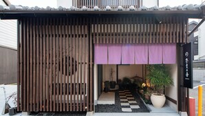 A traditional Japanese entrance with a wooden slat gate, a checkered pathway, and a potted plant. - Nara-no-ya (Nara)