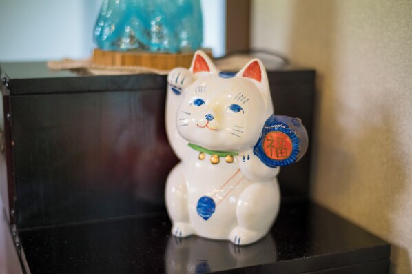 Una figurita de gato de cerámica con una etiqueta en la espalda.