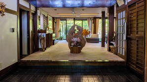 A traditional Japanese-style interior with wooden beams, tatami flooring, and a central sculpture. - Ryokan Yakenoyu (Takayama)