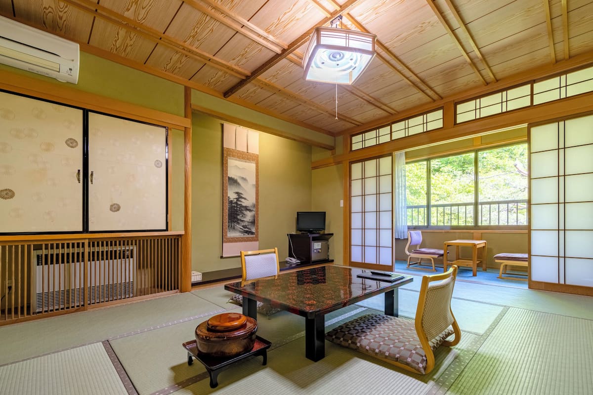 Een traditionele Japanse kamer met tatami vloerbedekking, een lage tafel en schuifdeuren.