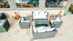 An outdoor seating area with wicker furniture and terracotta planters. - Captain James Camp (Naivasha)