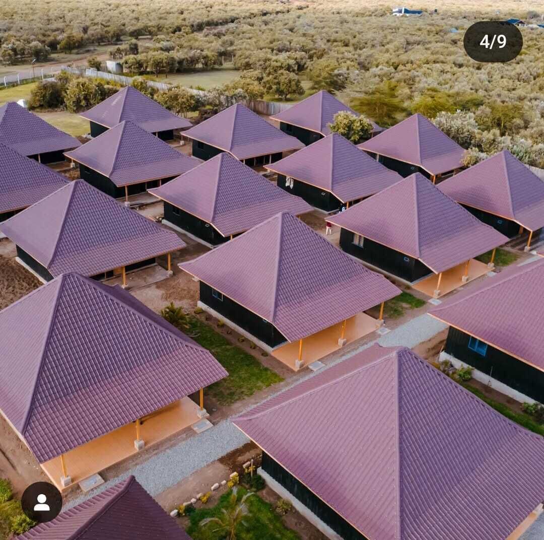 A series of modern, pyramid-shaped buildings with flat roofs, arranged in a grid pattern, surrounded by a natural landscape.