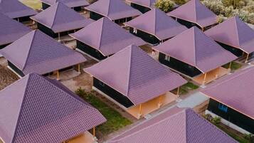 A series of modern, pyramid-shaped buildings with flat roofs, arranged in a grid pattern, surrounded by a natural landscape.