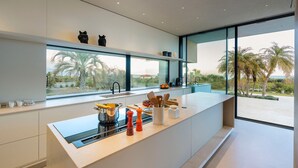 A modern kitchen with a large window, a built-in stove, and a countertop with various kitchen items. - Luxury villa with pool and spa - Dicasainsicilia (Riposto)