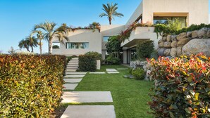 A modern house with a well-maintained garden, a stone pathway, and a palm tree. - Luxury villa with pool and spa - Dicasainsicilia (Riposto)