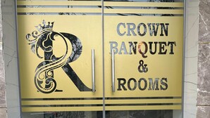 Una porta di vetro con la scritta "Crown Banquet & Rooms" e un emblema decorativo.