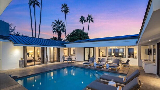 A modern house with a swimming pool, outdoor seating, and a view of palm trees. - Ozone Pool, Spa and Built-In Bar (Palm Springs)