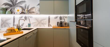 A compact kitchen with a built-in oven, a microwave, and a coffee maker.