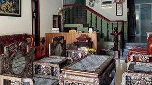 Un salon de style traditionnel, agrémenté de meubles richement décorés, d’un comptoir d’accueil et d’un escalier.