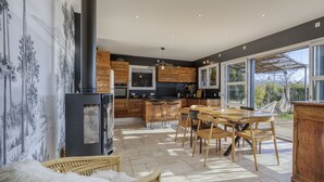Una cocina moderna con armarios de madera, una isla central y un amplio ventanal.