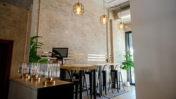A modern interior with a bar area, seating, and pendant lighting. - 22 Hostel (Chiang Mai)