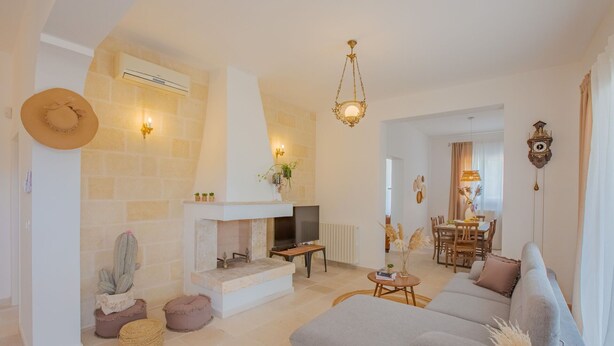 Una sala de estar con chimenea, sofá y comedor.