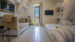 Un dormitorio acogedor con sofá, cama, televisor y balcón con vistas.