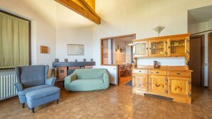 Amplia sala de estar con chimenea, una mesa de comedor y una cocina con armarios de madera.