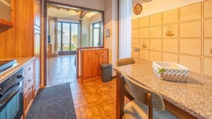 Una cocina con armarios de madera, encimera de granito y vistas a un balcón.