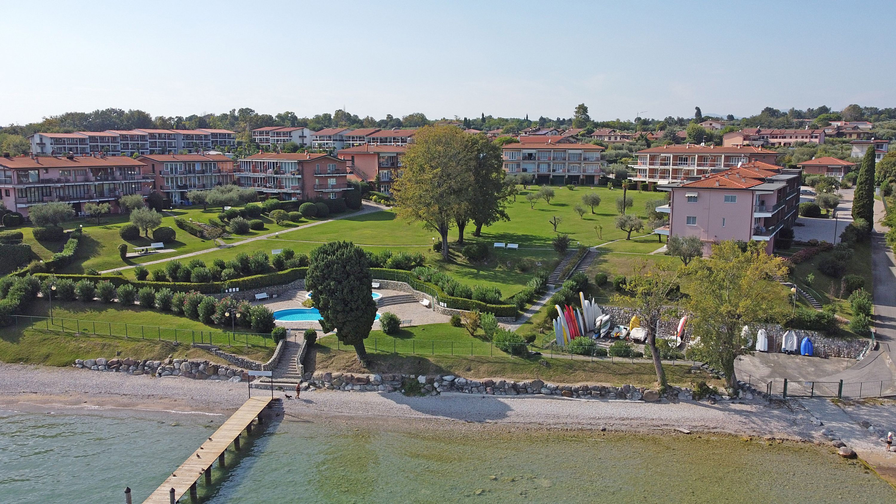 A residential area with a swimming pool, a dock, and a well-maintained garden.