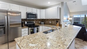 A modern kitchen with stainless steel appliances, granite countertops, and white cabinetry. - Out of Office - Lakeside Pool, Elevator, & Location! (Osage Beach)