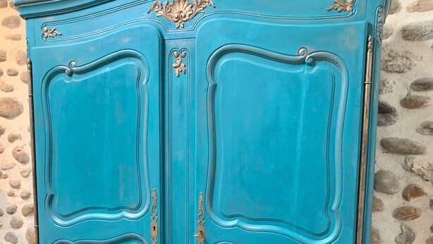 A turquoise vintage-style dresser with ornate handles and decorative elements, placed against a stone wall. - Vercors en vert (Saint-Romans)
