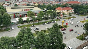 A cityscape with a prominent building labeled "DABACO MATIC" and a busy intersection with multiple vehicles. - AMY HOTEL (Kinh Bac)