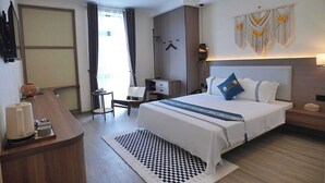 A hotel room with a large bed, a desk, a chair, a wardrobe, and a wall-mounted lamp. - AMY HOTEL (Kinh Bac)