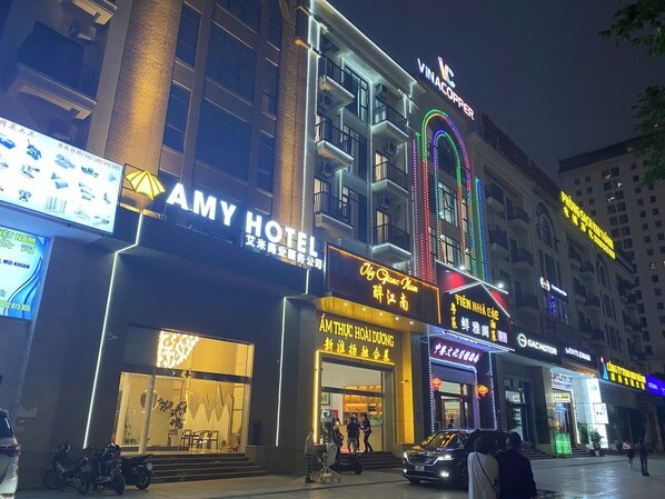 A hotel with a prominent sign for 'AMY HOTEL' and 'VINAC COPPER' above the entrance.