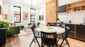 A modern apartment with a dining area, kitchen, and living room.