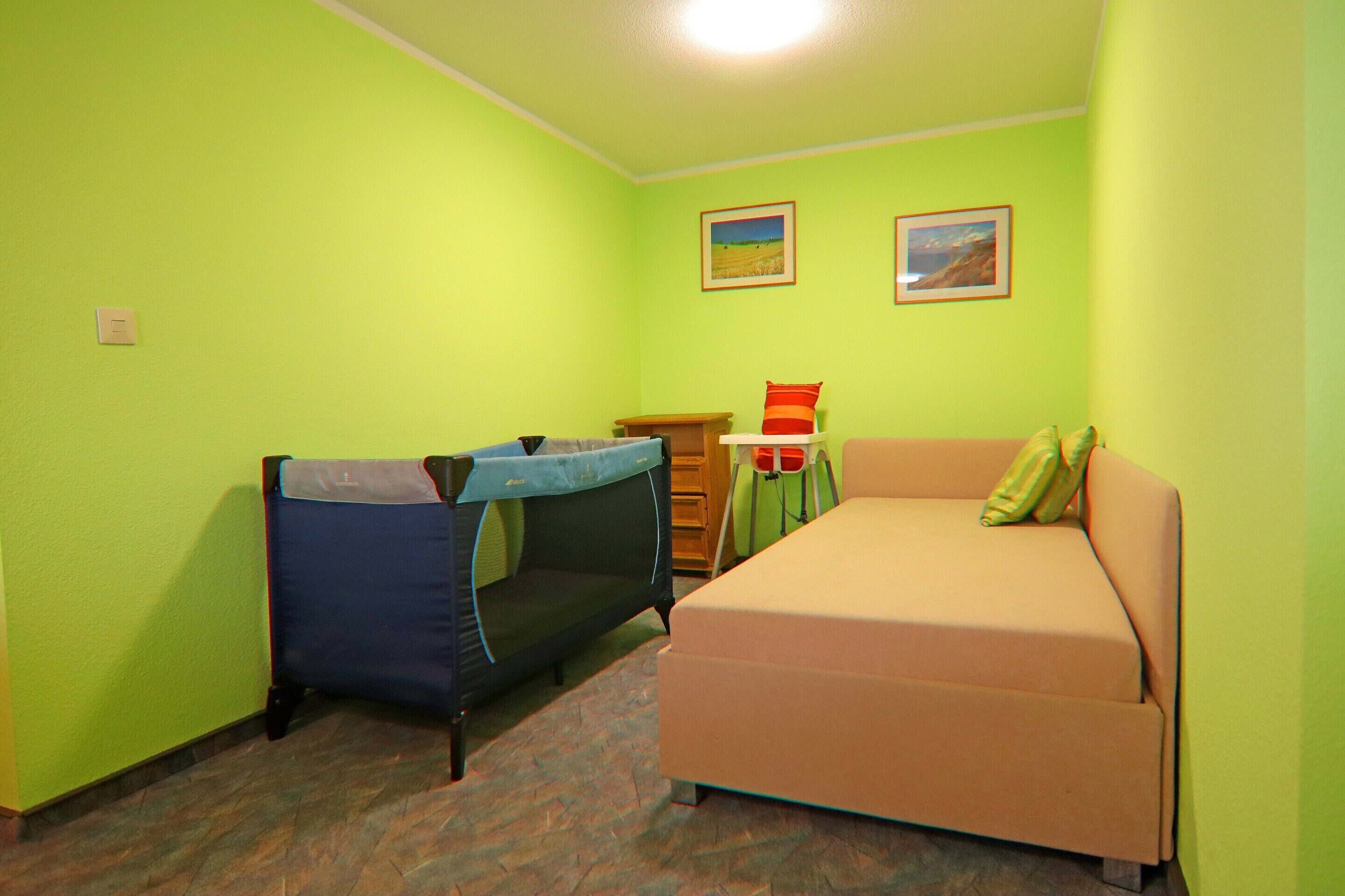 A room with a bed, a small table, and a chair.