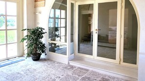 Ein geräumiger Eingangsbereich mit einem großen Bogen, einem Blumentopf und Blick ins Innere.