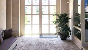 Ein geräumiges Zimmer mit einer hohen, gewölbten Decke, einem großen, bogenförmigen Durchgang und einem Blumentopf.